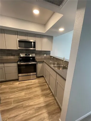 a kitchen with stainless steel appliances granite countertop a stove and a sink