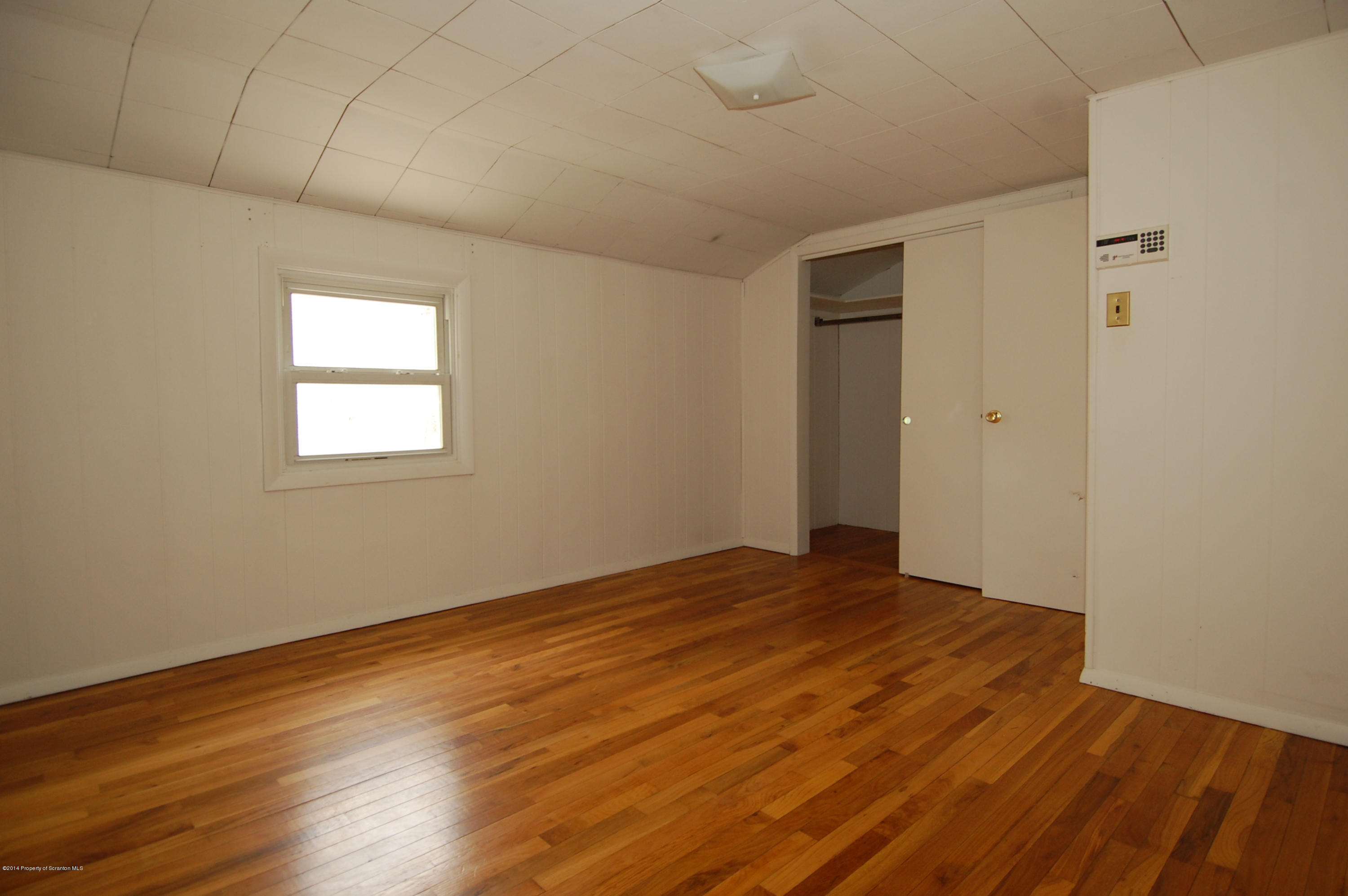 1129 Corbin Road Kingsley, PA 18826 - Photo 9 of 24 a view of an empty room with wooden floor and a window
