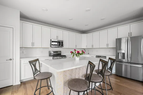 a kitchen with granite countertop white cabinets and stainless steel appliances