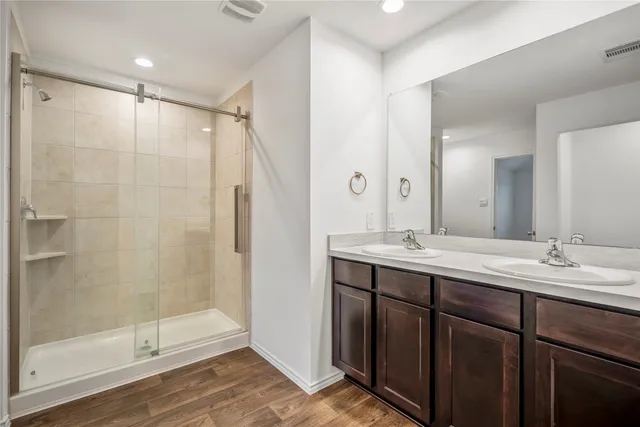 a bathroom with a double vanity sink mirror and shower