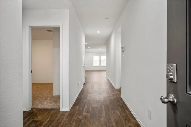 a view of a hallway with wooden floor