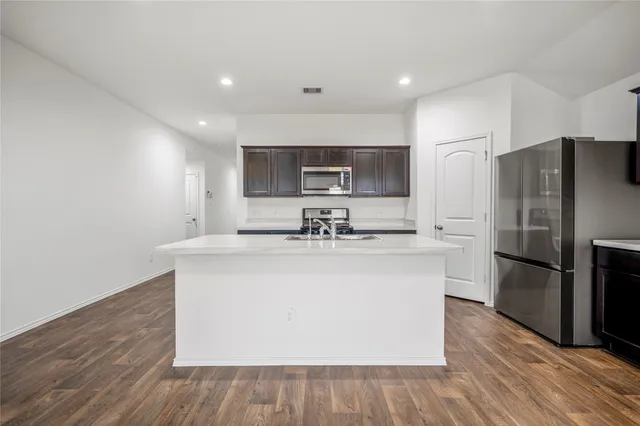 a view of kitchen with stainless steel appliances a sink and a refrigerator