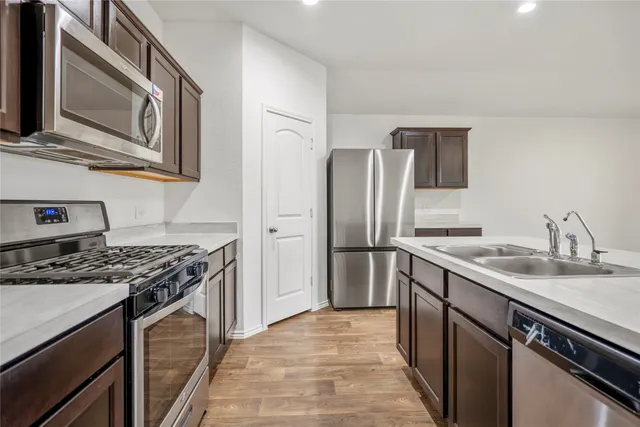 a kitchen with stainless steel appliances granite countertop a sink stove and refrigerator