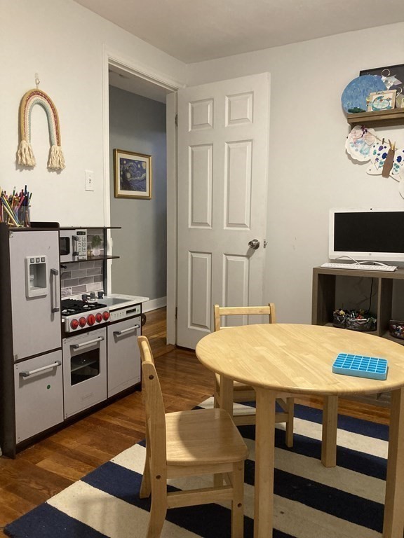 24 Baxter Street Worcester, MA 01602 - Photo 26 of 36 a kitchen with a stove a microwave and a dining table
