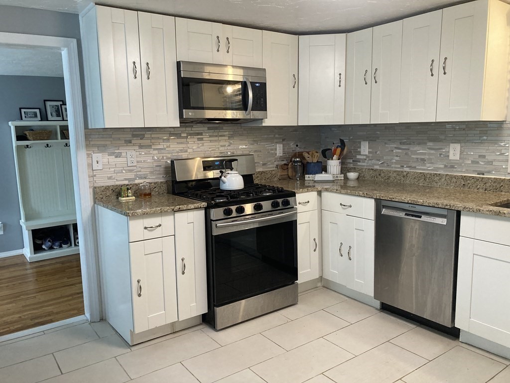 24 Baxter Street Worcester, MA 01602 - Photo 9 of 36 a kitchen with stainless steel appliances granite countertop a stove a sink and a microwave