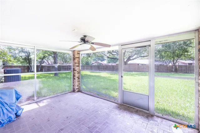 a view of a room with a big yard and large tree