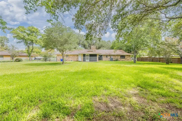 a view of a house with yard and sitting area