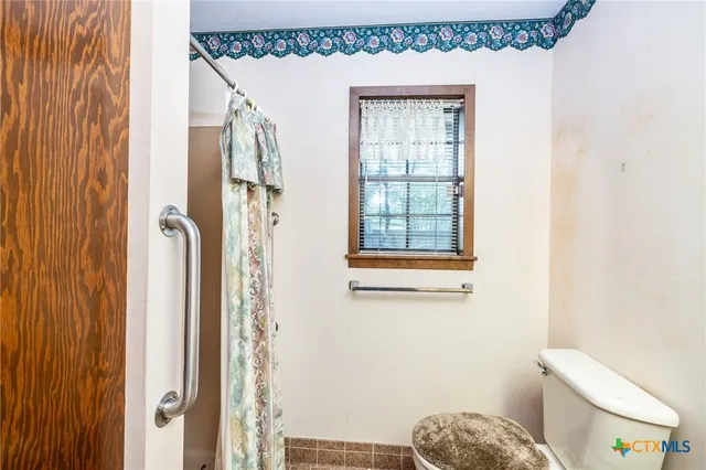 a bathroom with a toilet a sink and a window