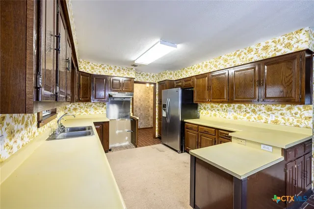 a kitchen with a sink stove and refrigerator