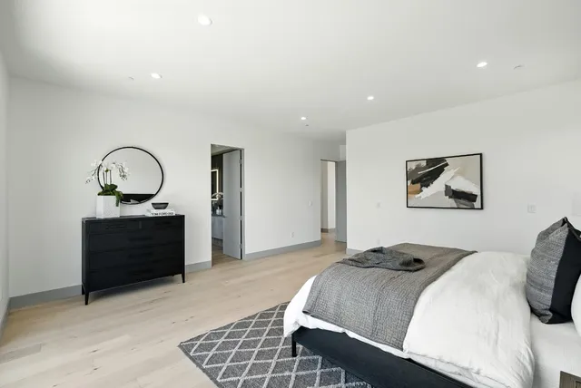 a view of a bedroom with wooden floor and a hallway