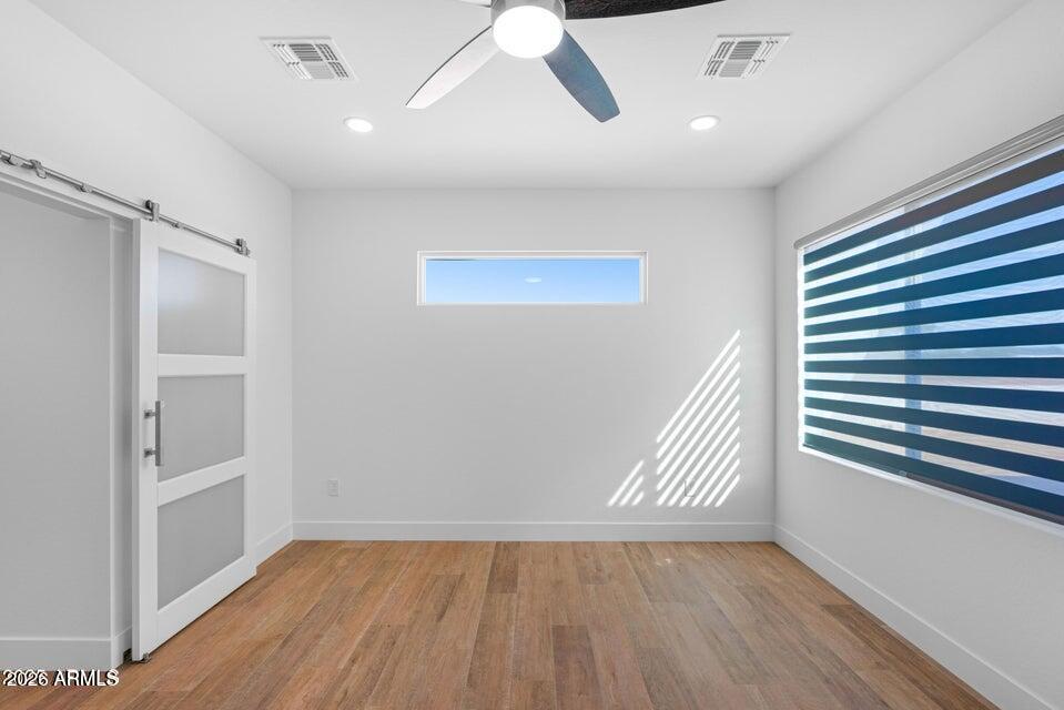 14833 South Brook Hollow Road Arizona City, AZ 85123 - Photo 22 of 61 an empty room with wooden floor and windows