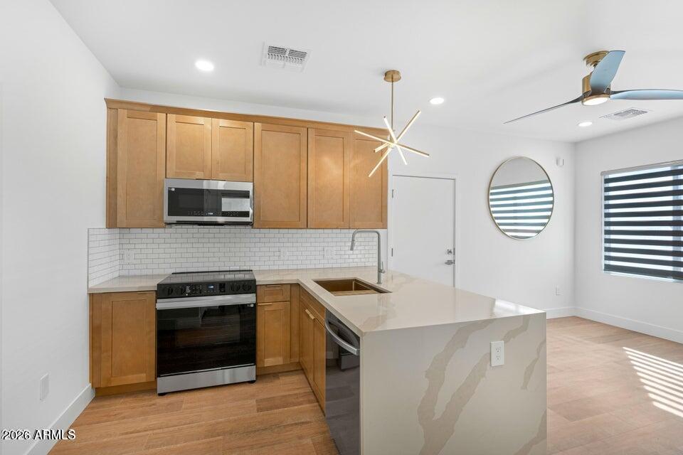 14833 South Brook Hollow Road Arizona City, AZ 85123 - Photo 38 of 61 a kitchen that has a sink and a stove top oven