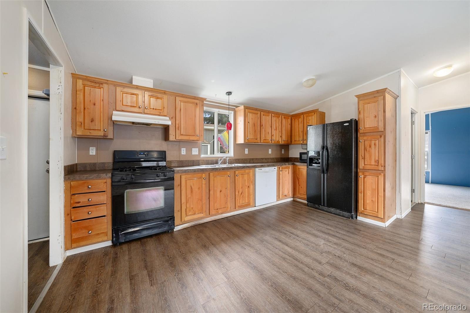 2500 East Harmony Road Fort Collins, CO 80528 - Photo 7 of 23 a kitchen with granite countertop a refrigerator and a stove top oven