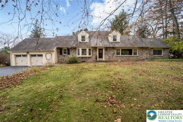 a front view of a house with yard and trees