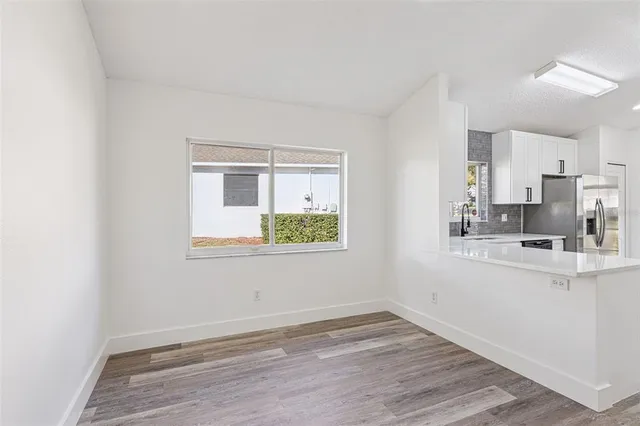 a view of empty room with wooden floor