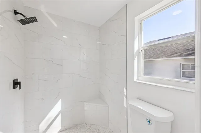 an aerial view of a residential houses with outdoor space and trees all around