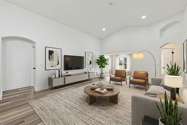 a living room with furniture a flat screen tv and a window