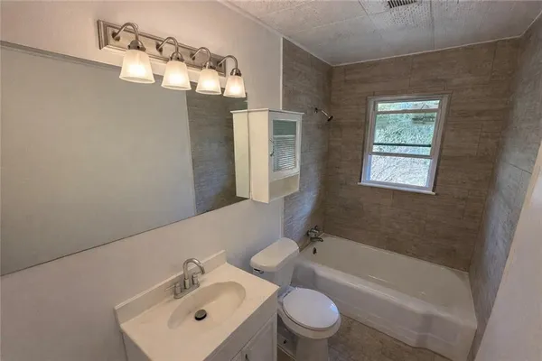 a bathroom with a toilet bathtub and window