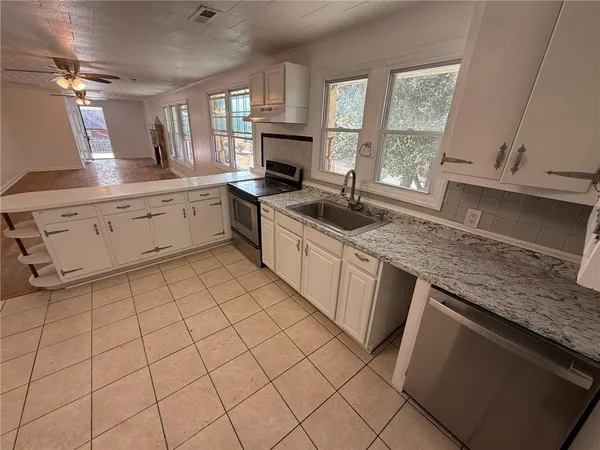 a kitchen with stainless steel appliances a refrigerator and a stove top oven