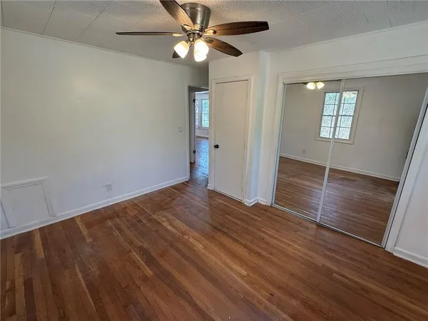 a view of an empty room with a window and wooden floor