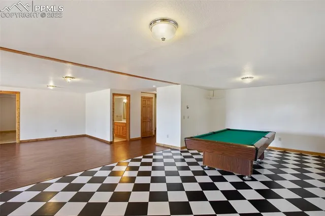 a room with pool table and windows