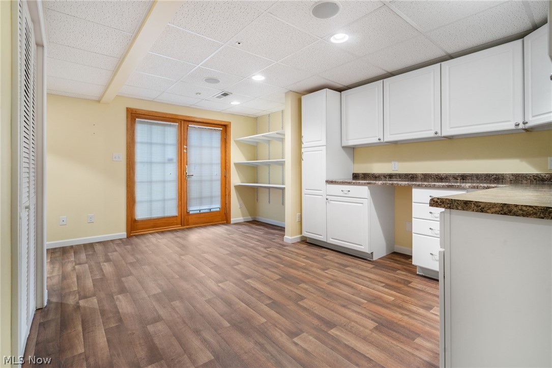 2414 Charing Cross Road Northwest Canton, OH 44708 - Photo 24 of 36 Lower-level craft room with white cabinets, hardwood / wood-style flooring, and a paneled ceiling