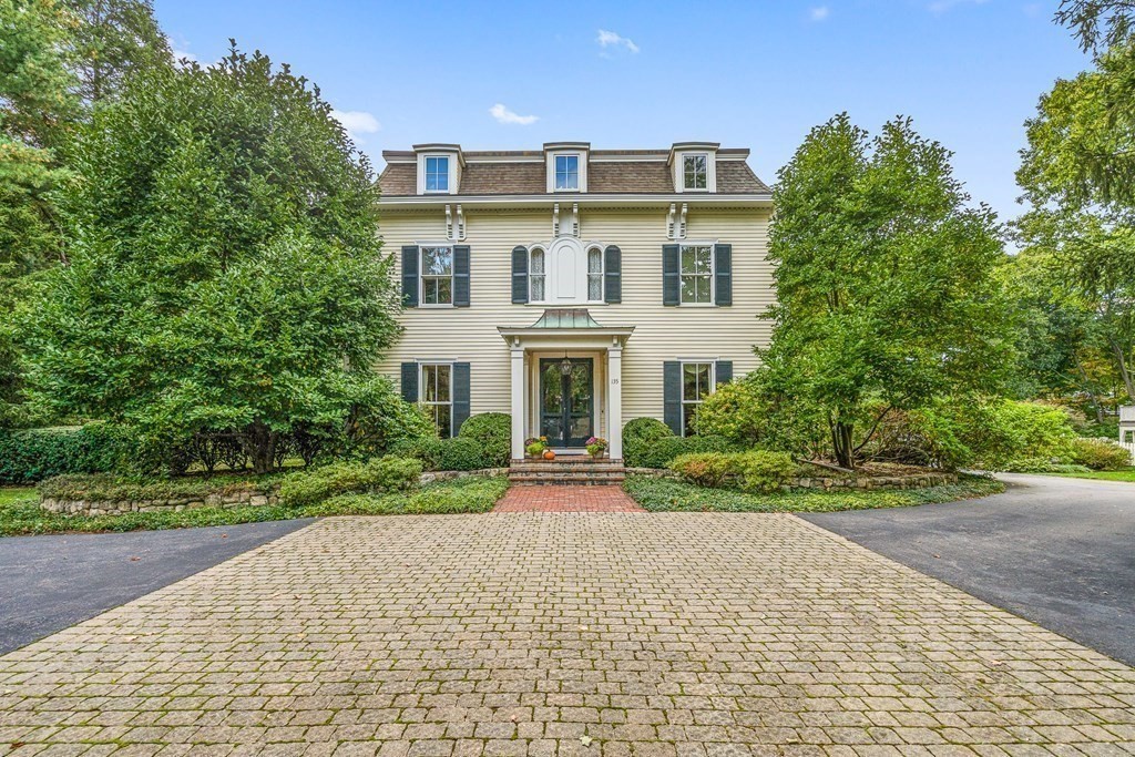 a front view of a house with a yard and a garden