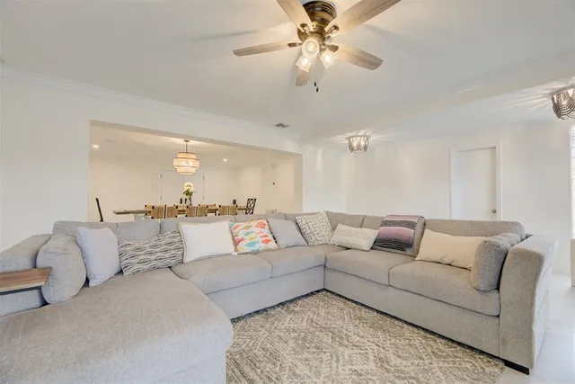 a living room with furniture and a ceiling fan