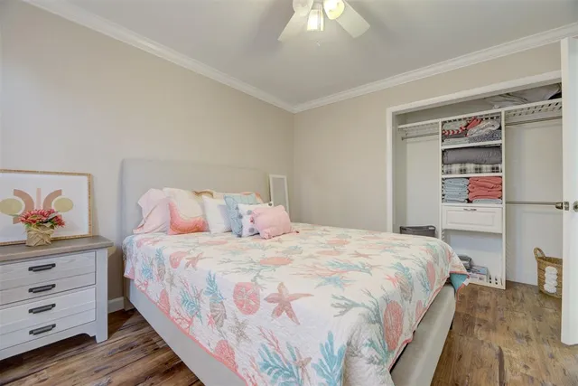 a large bed sitting in a bedroom next to a window and a chandelier