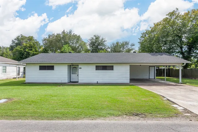 a front view of a house with yard and green space