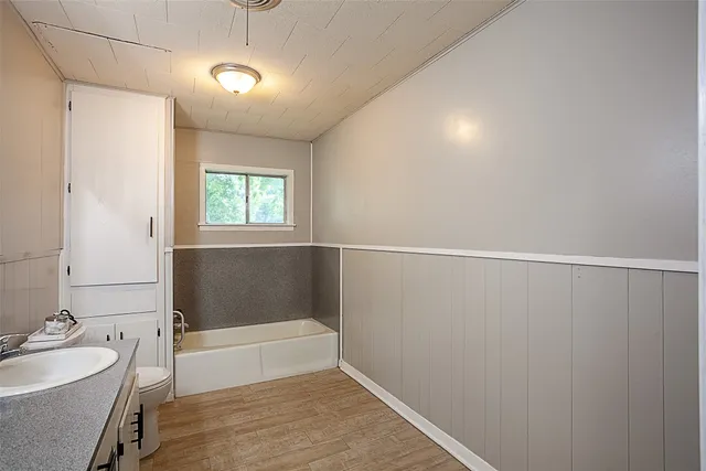 a bathroom with a sink a tub and a mirror