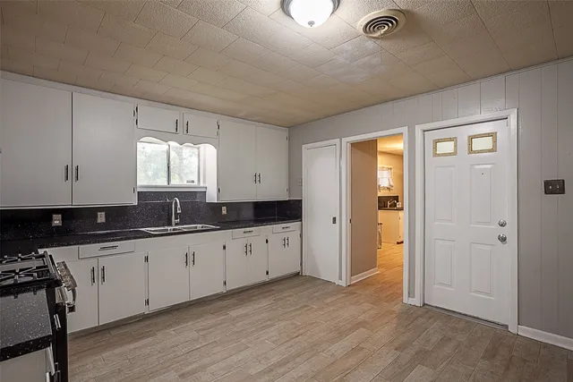 a kitchen with granite countertop white cabinets and stainless steel appliances