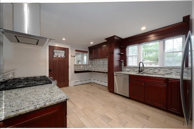 a kitchen with stainless steel appliances granite countertop a sink stove and refrigerator