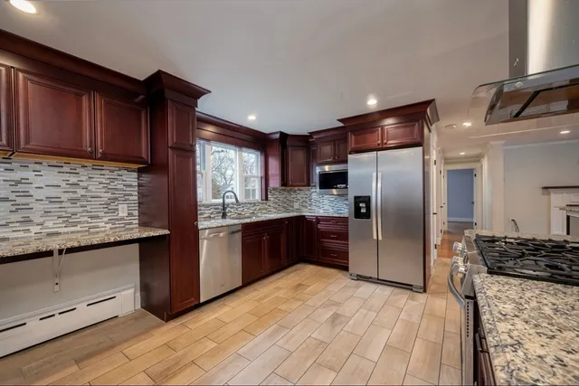 a kitchen with stainless steel appliances granite countertop a refrigerator and a sink