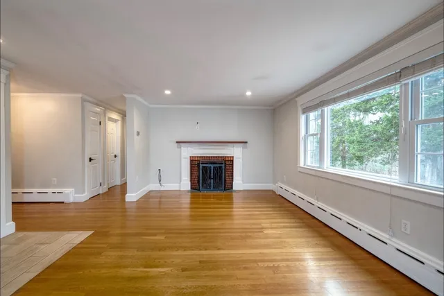 a view of an empty room with a fireplace and large windows