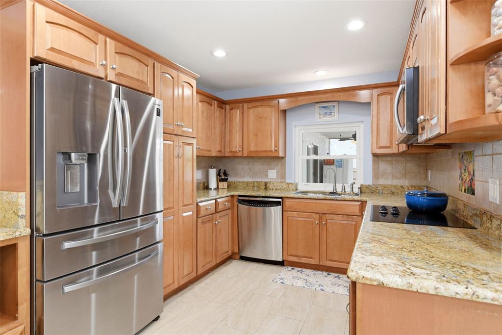 7432 Sparkling Lake Road Orlando, FL 32819 - Photo 13 of 54 a kitchen with granite countertop stainless steel appliances a refrigerator stove top oven and sink