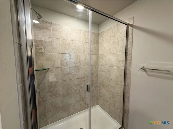 a bathroom with a glass shower door