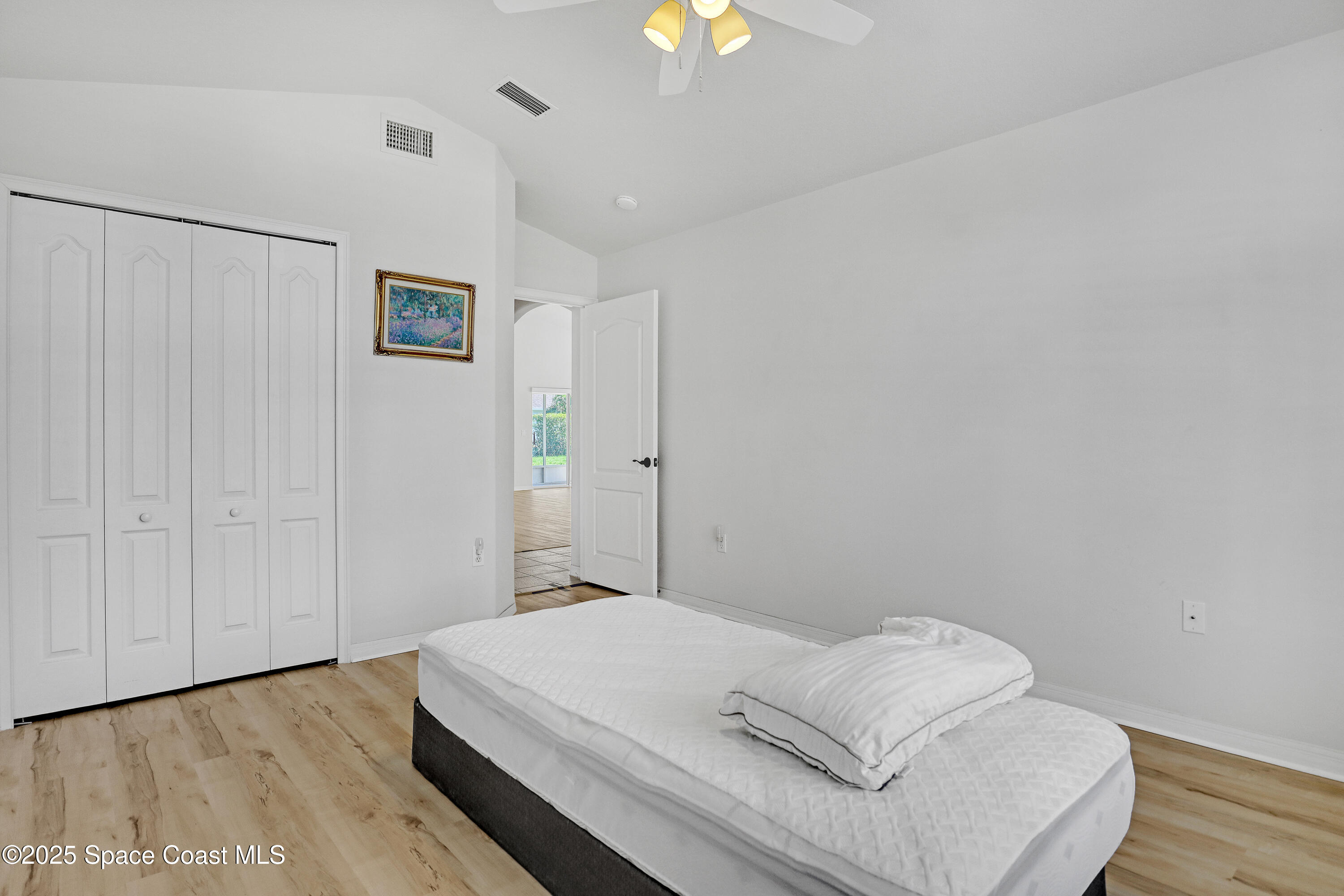 1692 Keys Gate Drive Melbourne, FL 32940 - Photo 20 of 26 a bedroom with a bed and a chandelier