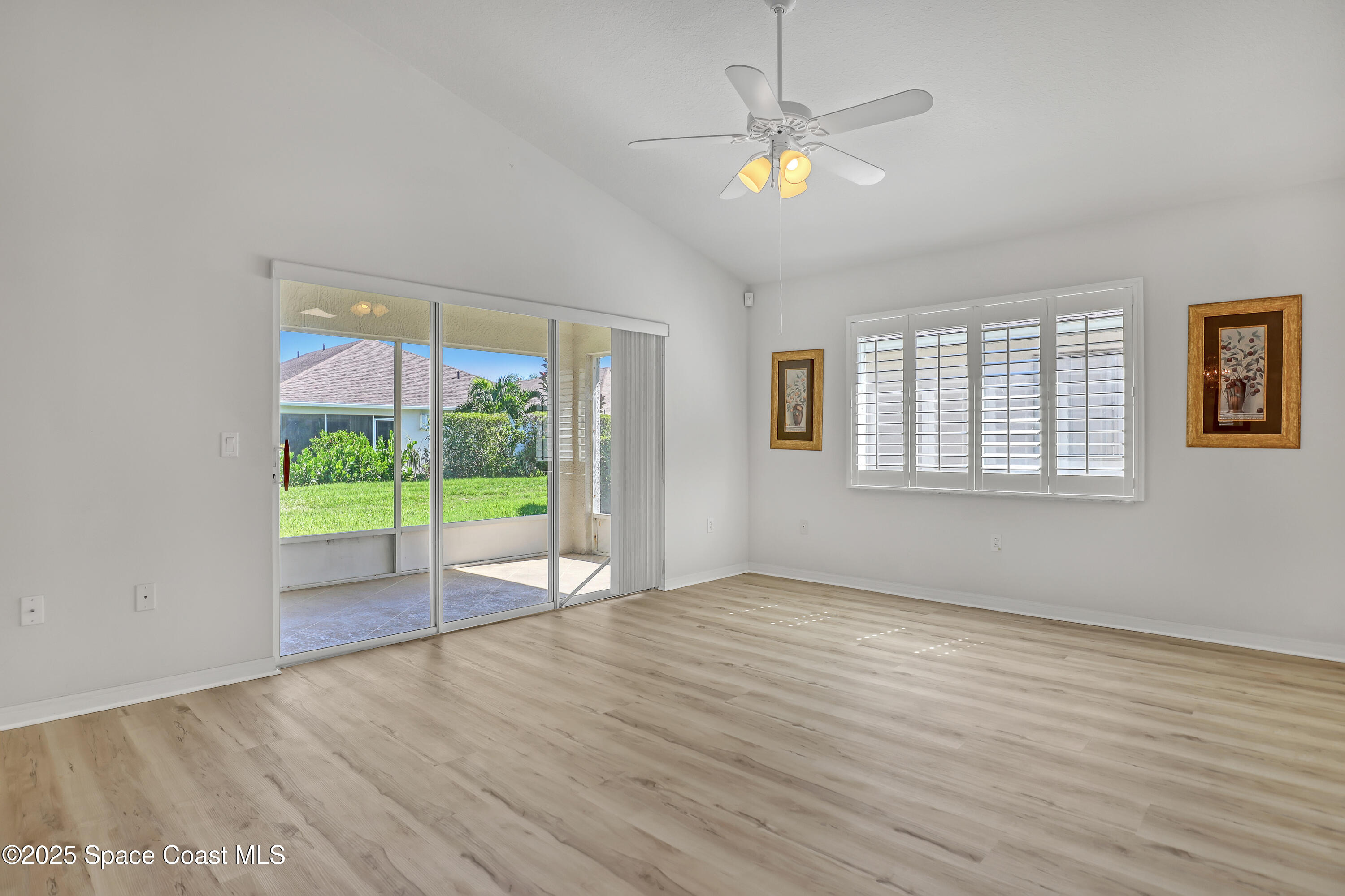 1692 Keys Gate Drive Melbourne, FL 32940 - Photo 5 of 26 an empty room with wooden floor fan and windows