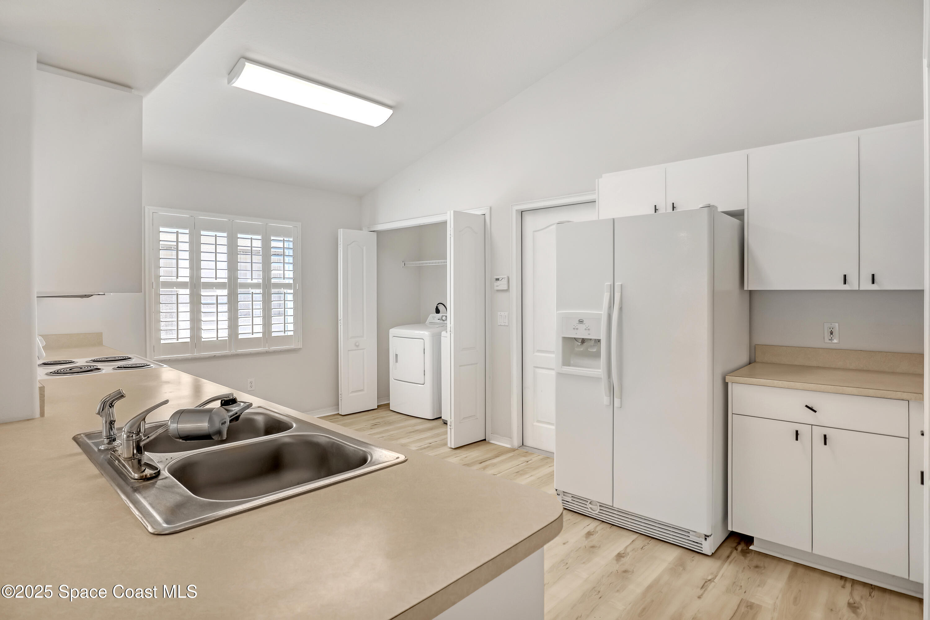 1692 Keys Gate Drive Melbourne, FL 32940 - Photo 9 of 26 a kitchen with stainless steel appliances a sink a refrigerator and white cabinets