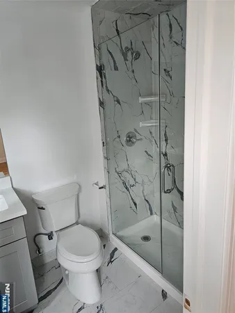 a bathroom with a shower a toilet and a sink