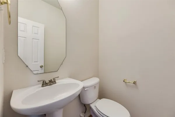 a bathroom with a sink mirror and toilet