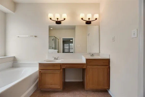 a bathroom with a granite countertop sink a large mirror and a bathtub