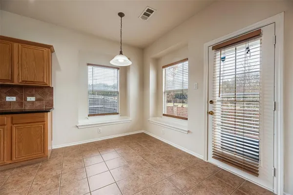 a view of an empty room with a window and chandelier