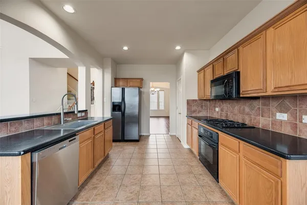 a large kitchen with stainless steel appliances granite countertop a sink and a stove