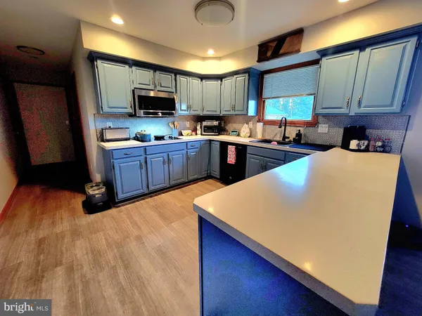 a kitchen with sink a refrigerator and chairs