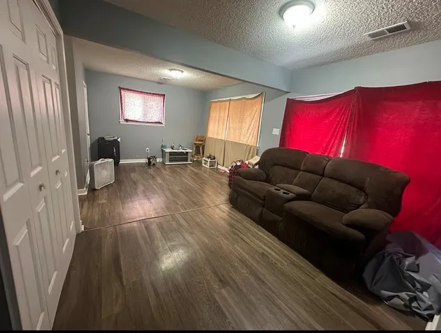 a living room with furniture and a wooden floor