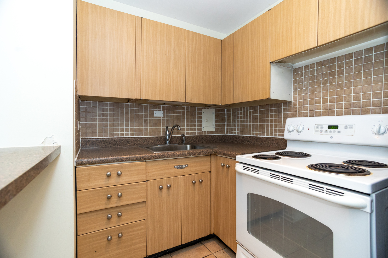 5701 North Sheridan Road, Unit 9N Chicago, IL 60660 - Photo 11 of 17 a kitchen with granite countertop cabinets sink stove and white cabinets