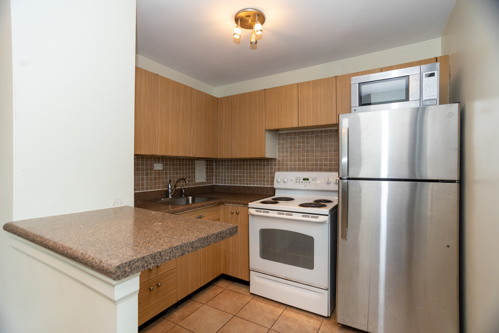 5701 North Sheridan Road, Unit 9N Chicago, IL 60660 - Photo 10 of 17 a kitchen with a stove a refrigerator and a sink