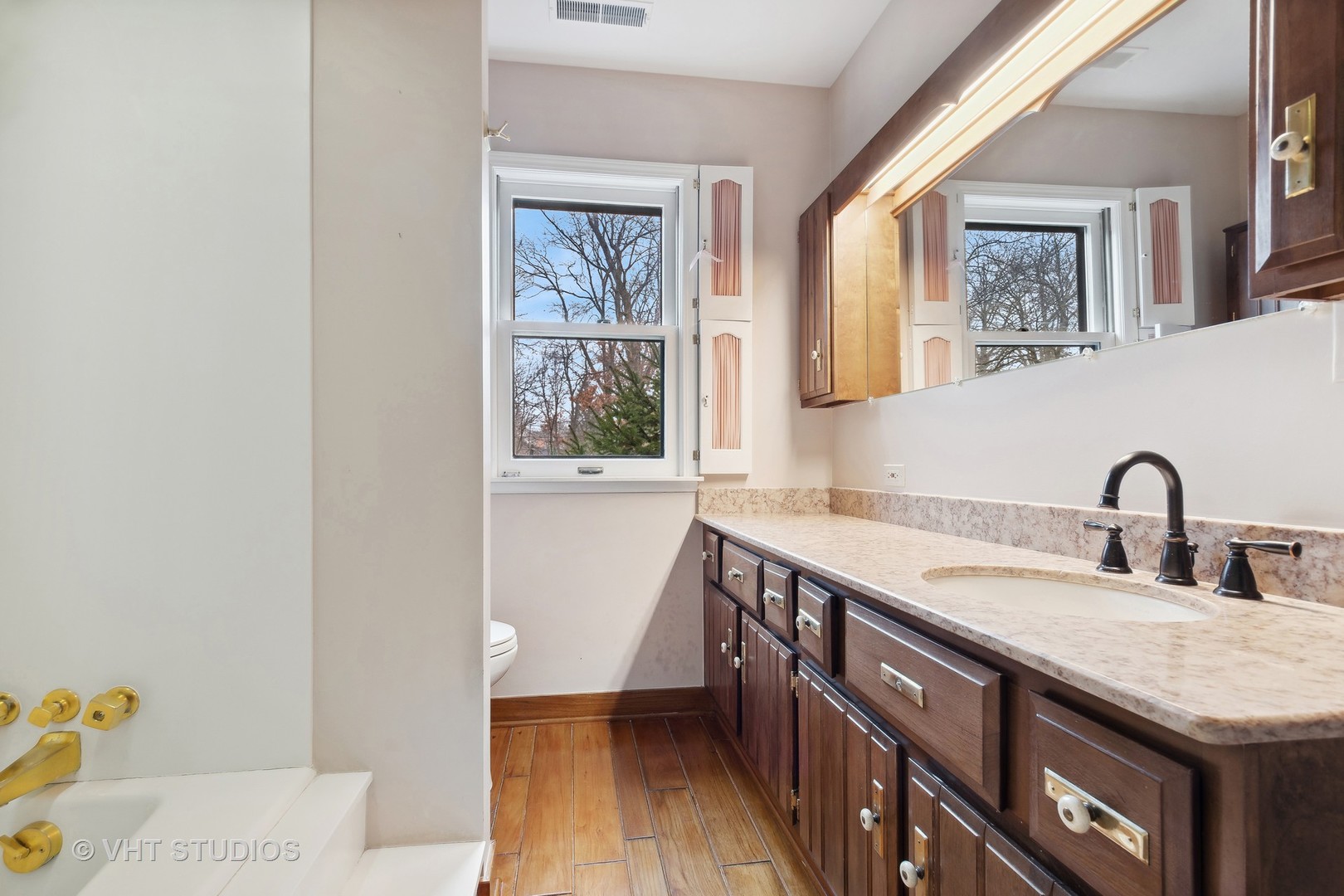 835 Heather Road Deerfield, IL 60015 - Photo 15 of 29 a bathroom with a granite countertop sink a mirror and a window